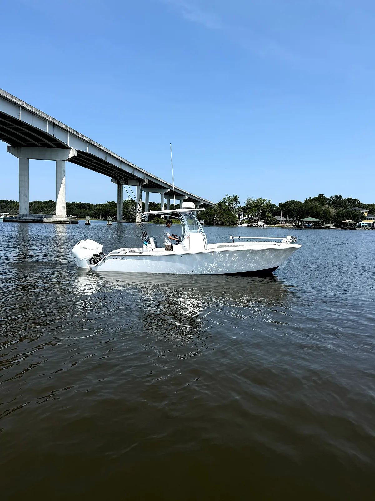 The 26-foot Front Runner running the river under the bridge, captain at the helm